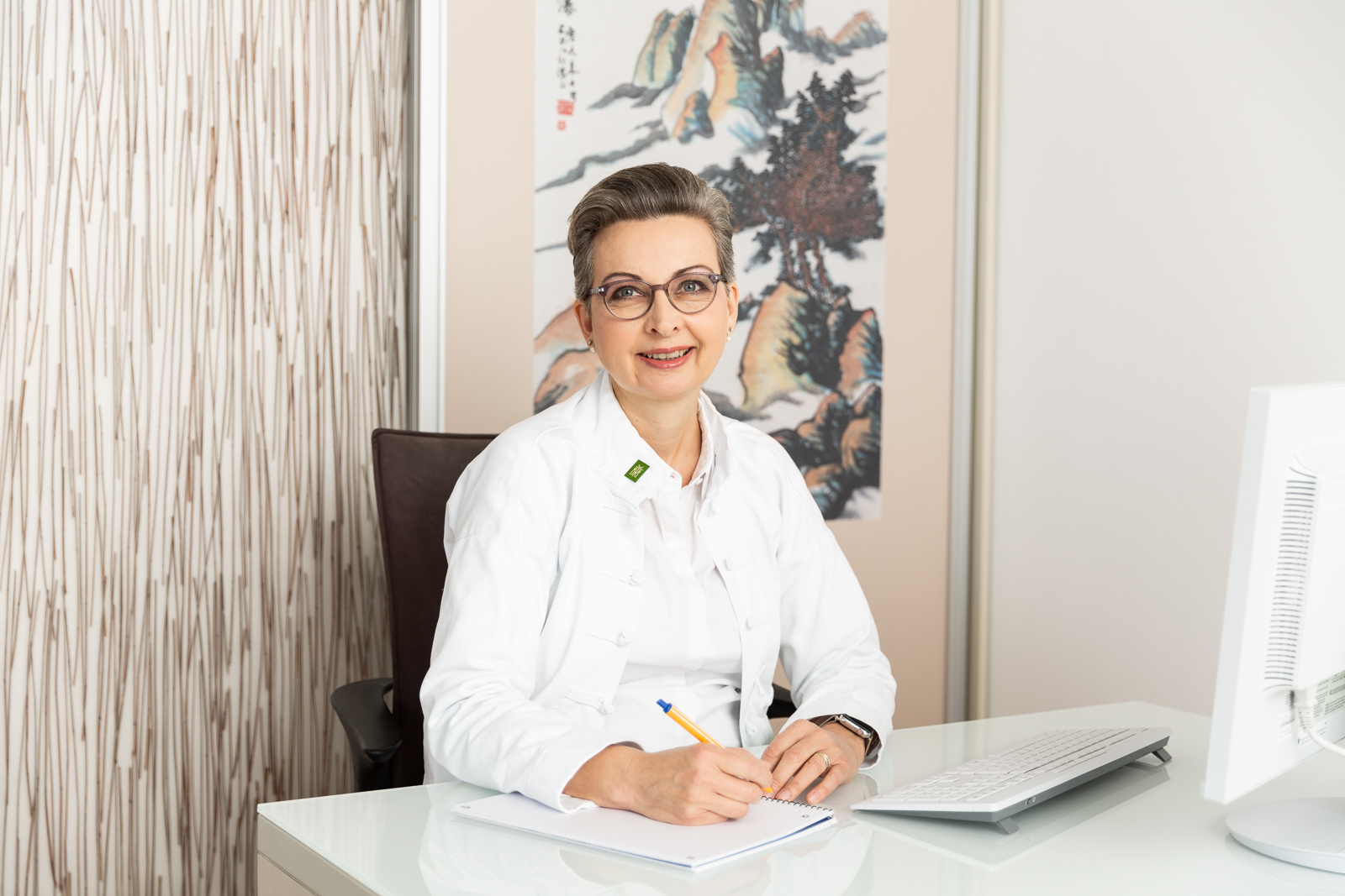 Frau Dr. med. Winckler-Schumann am Schreibtisch mit Notizblock
